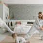A joyful family bonding through morning stretches in a cozy bedroom setting.